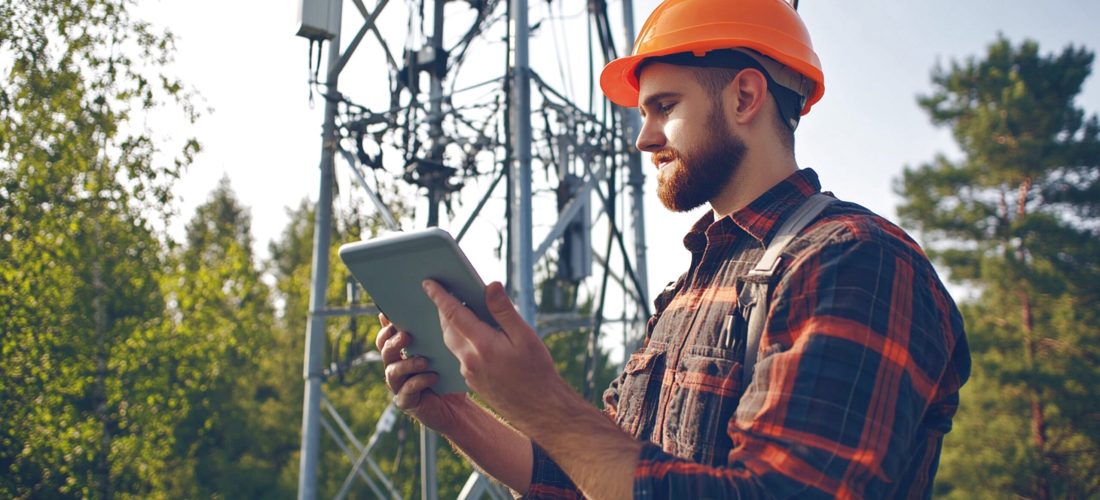 Engineer works in the field with a telecommunication tower